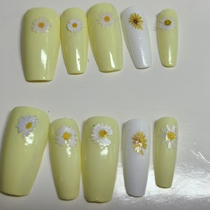 Pastel yellow and white nails with flower details
