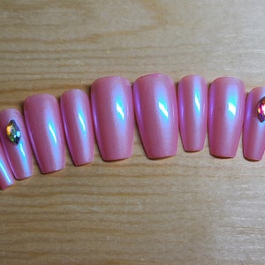 May include: Set of ten pink iridescent coffin-shaped false nails with rhinestones.