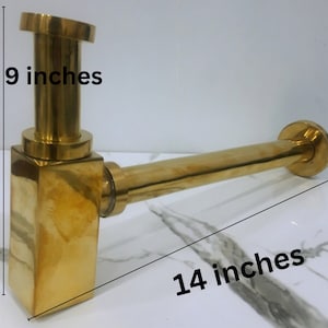 May include: A gold-colored metal drain pipe with a square base and a round outlet. The pipe is 14 inches long and the base is 5 to 9 inches tall.