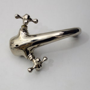 Pode incluir: Uma torneira cromada polida com duas al&ccedil;as em forma de cruz. A torneira tem um bico curvo e &eacute; projetada para uma pia de banheiro.