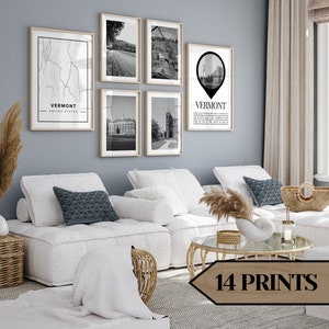 Könnte beinhalten: Ein Wohnzimmer mit einer Galeriewand mit sieben gerahmten Drucken. Die Drucke zeigen Schwarz-Weiß-Bilder von Vermont, darunter eine Karte, Landschaften und Gebäude. Der Raum hat eine moderne Ästhetik mit weißen Sofas, dekorativen Kissen und einem Couchtisch.