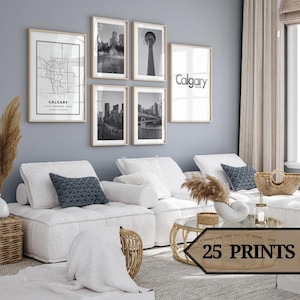Könnte beinhalten: Ein Wohnzimmer mit gerahmten Kunstdrucken mit Calgary-Motiven. Die Drucke zeigen eine Karte, Stadtansichten und den Namen der Stadt. Das Zimmer hat ein weißes Sofa, Kissen und einen Couchtisch mit Glasplatte. Der Text "25 PRINTS" ist sichtbar.