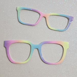 May include: Two pairs of rainbow glitter glasses. The glasses are a light pink, blue, yellow, and green color. The glasses are made of plastic and have a rounded shape.