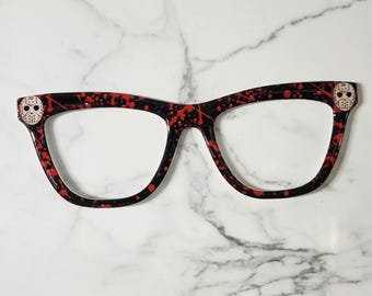 Peut inclure: Lunettes noires et rouges éclaboussées de peinture avec un masque décoratif de Jason Voorhees sur chaque branche. Les lunettes ont une forme œil de chat et sont conçues pour un usage de costume ou de fantaisie.