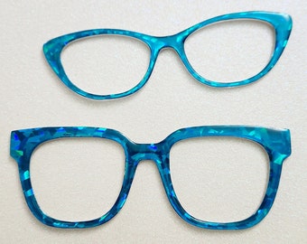 May include: Two pairs of blue iridescent glasses. The top pair has a cat-eye shape, while the bottom pair has a more rectangular shape.
