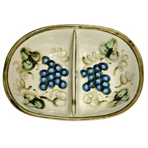 May include: A divided serving dish with a white background and brown rim. The dish is decorated with a grapevine design in green and brown, with blue grapes.