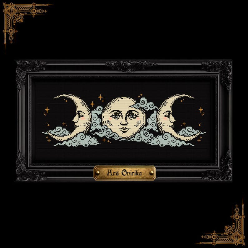 May include: A cross-stitch embroidery featuring a triple moon motif with a central full moon and two crescent moons, all with human faces, surrounded by light blue clouds and small gold stars on a black background, framed in a black ornate frame with a gold plaque reading Ars Onirika.