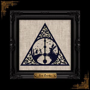 May include: A dark blue cross-stitch embroidery featuring a triangular frame with intricate scrollwork, a central vertical line, and a circular motif. The design depicts silhouettes of figures on cliffs under a starry sky. A gold plaque reads Ars Onirika.