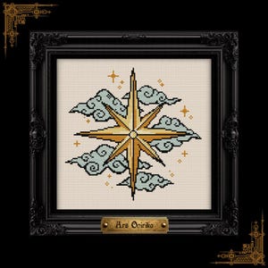 May include: A cross-stitch embroidery featuring a golden eight-pointed star surrounded by light blue stylized clouds and small orange stars on a cream fabric background, encased in a black ornate frame with a plaque reading Ars Onirika.