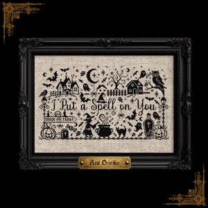 May include: A black cross-stitch embroidery on light beige fabric featuring the text I Put a Spell on You, surrounded by Halloween motifs including a witch, cauldron, bats, ghosts, pumpkins, and a haunted house, encased in a black ornate frame.