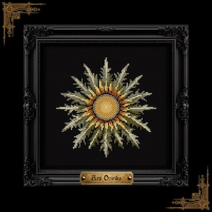 May include: A framed cross-stitch artwork featuring a stylized sunburst design in shades of gold, green, and cream against a black background. The artwork is in a black ornate frame with the text "Ars Opirika" on a small plaque.