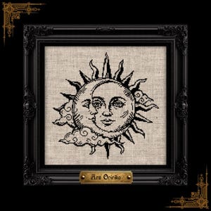 May include: A black and white cross-stitch embroidery of a sun and moon face design on light beige fabric, housed in an ornate black frame with a small gold plaque at the bottom featuring the text Ars Onirika in a decorative black font.
