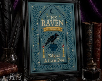 May include: A framed cross-stitch embroidery featuring a blue background with a black raven perched on a pedestal. The text reads THE RAVEN, Nevermore, and Edgar Allan Poe. The design includes a crescent moon, stars, and two lit candles.