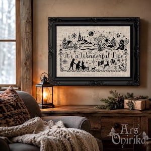 May include: A black and white cross-stitch embroidery in a black ornate frame featuring a winter village scene with trees, a moon, and the text It's a Wonderful Life. The design includes silhouettes of people, a reindeer, and snowflakes.