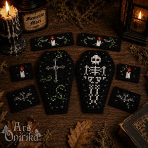 May include: A collection of black cross-stitch patches featuring white and green thread designs, including two coffin shapes, one with a cross and one with a skeleton, surrounded by smaller rectangular patches depicting candles and bats.