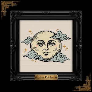 May include: Cross-stitch art of a smiling moon with rosy cheeks, surrounded by blue clouds and gold stars. The artwork is framed in a black ornate frame with the text "Ars Onirika" on a small plaque.