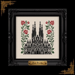 May include: A framed cross-stitch artwork featuring a black and white cathedral design, flanked by red roses and green foliage. The artwork is set against a cream background and framed in a black ornate frame. A small brass plaque at the bottom reads "Ars Opirika".