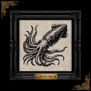 May include: A black and white cross-stitch embroidery of a squid on a light beige fabric background, encased in an ornate black frame. A small rectangular brass-colored plaque at the bottom of the frame features the text Ars Onirika.