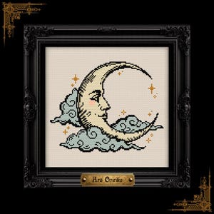 May include: A cross-stitch embroidery featuring a crescent moon with a human face, pink cheeks, and gold stars, surrounded by light blue clouds on a cream fabric background, encased in a black ornate frame with a plaque reading Ars Onirika.