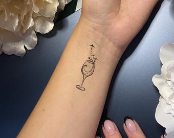 Tatuaje temporal de avión con copa de vino