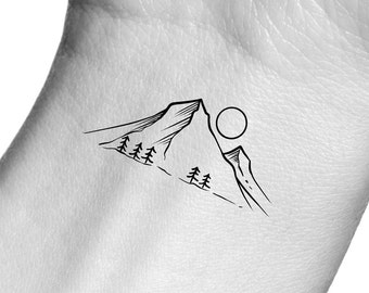 May include: A black and white line drawing of a mountain range with a sun above it. The mountain range has a few trees on the side.