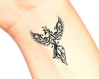 May include: A black tribal style phoenix tattoo design on a person's wrist.