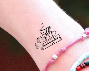 May include: A black and white line drawing of a cup of coffee on top of a stack of books. The cup has a heart on it.