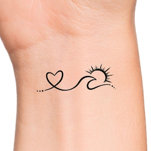 May include: A simple black line drawing tattoo design of a heart, wave, and sun on a person's wrist.