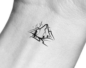May include: A black and white line art tattoo design of a mountain range with trees and stars.