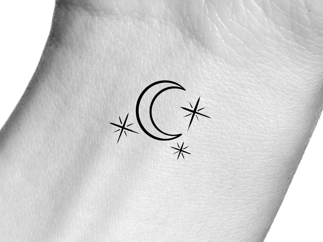 Minimlistic style crescent moon and stars tattoo done