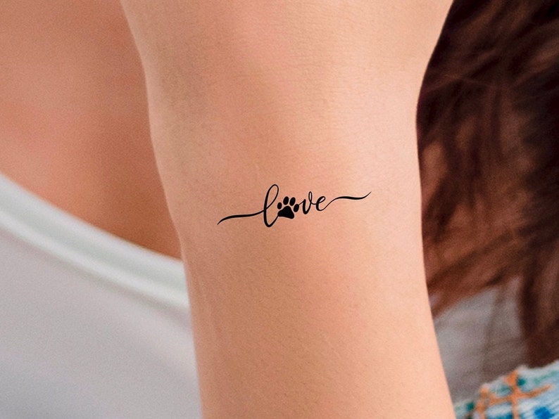 May include: A temporary tattoo with the word "love" written in cursive with a paw print in the middle of the word.