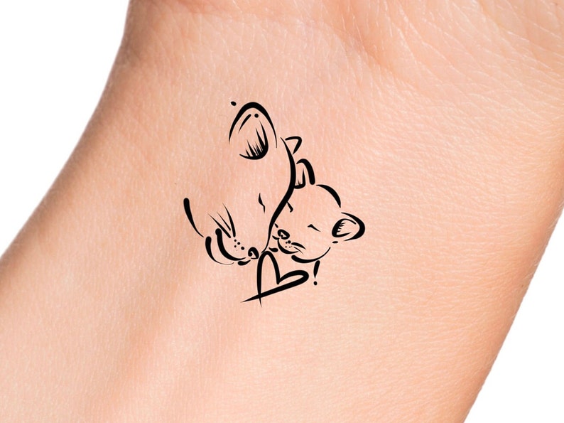 Puede incluir: Un dise&ntilde;o de tatuaje en blanco y negro de l&iacute;nea de arte de dos gatos abraz&aacute;ndose con un coraz&oacute;n en el medio.