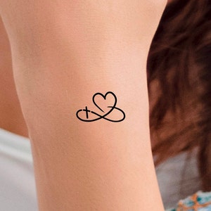 Pu&ograve; includere: Un tatuaggio temporaneo con un cuore e una croce intrecciati in un simbolo di infinito.