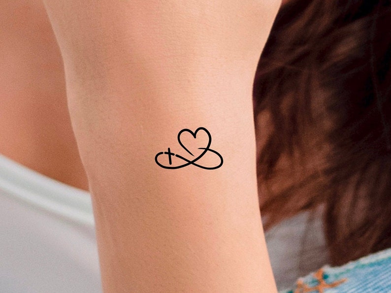Pu&ograve; includere: Un tatuaggio temporaneo con un cuore e una croce intrecciati in un simbolo di infinito.