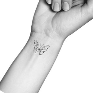 Op de afbeelding: Een eenvoudige lijntekening van een vlinder-tattoo op de pols van een persoon.