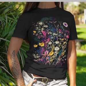 Peut inclure: T-shirt noir avec un imprim&eacute; floral color&eacute;. Les fleurs sont dans des tons de rose, jaune, bleu et vert. L'impression est de style aquarelle.