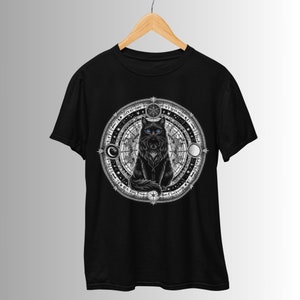Könnte beinhalten: Schwarzes T-Shirt mit einem Motiv einer schwarzen Katze, die in einem Kreis aus himmlischen Symbolen sitzt, darunter Monde, Sterne und Runen.