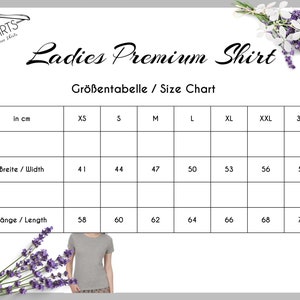 Peut inclure: Tableau des tailles pour un t-shirt premium pour femme, indiquant les mesures en centim&egrave;tres pour la largeur et la longueur. Le tableau comprend les tailles XS &agrave; 3XL.