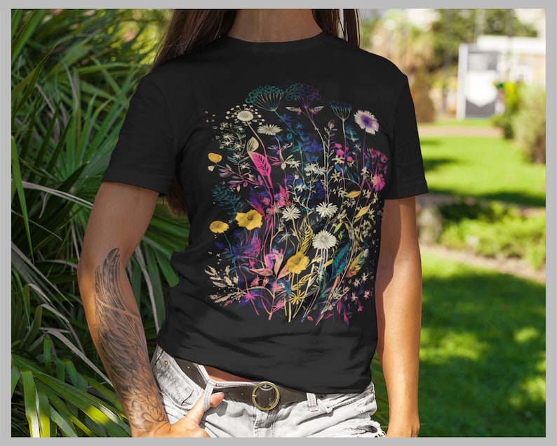 Peut inclure: T-shirt noir avec un imprim&eacute; floral color&eacute;. Les fleurs sont dans des tons de rose, jaune, bleu et vert. L'impression est de style aquarelle.