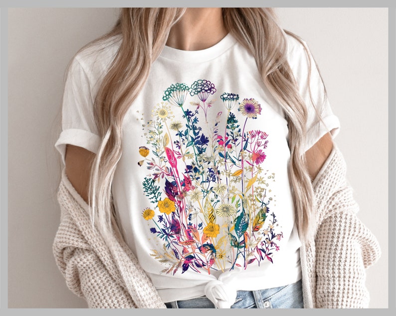 Peut inclure: T-shirt blanc avec un imprim&eacute; floral color&eacute; compos&eacute; de diff&eacute;rentes fleurs et feuilles dans des tons de rose, violet, jaune, vert et bleu.
