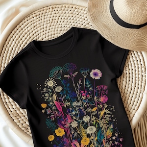 Peut inclure: T-shirt noire avec un imprim&eacute; floral color&eacute;. Les fleurs sont dans des tons de rose, bleu, jaune et vert. Le t-shirt a un col rond et des manches courtes.