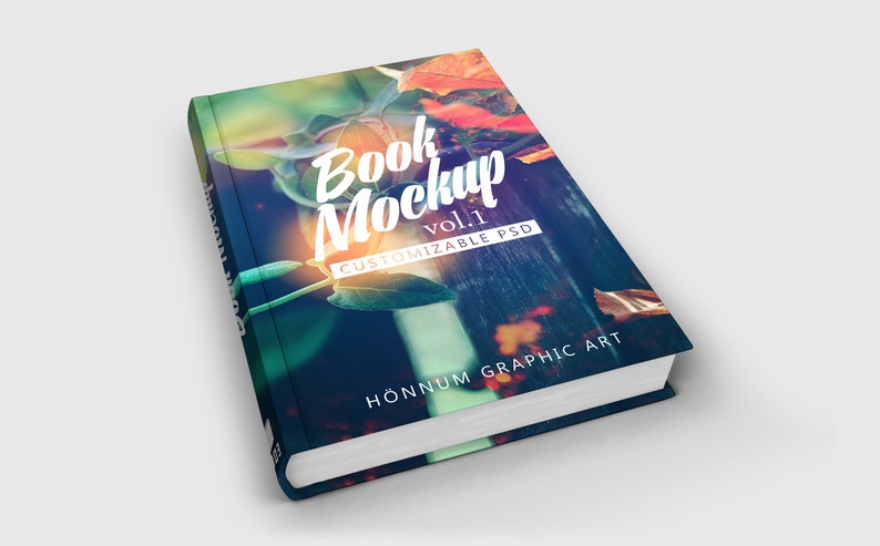 K&ouml;nnte beinhalten: Ein Buch-Mockup mit einem bunten, verschwommenen Hintergrund aus Bl&auml;ttern und einem Holzzaun. Der Text "Book Mockup vol.1 CUSTOMIZABLE PSD" befindet sich auf dem Cover. Der Text "H&Ouml;NNUM GRAPHIC ART" befindet sich am unteren Rand des Covers.