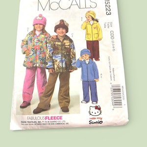 May include: McCall's sewing pattern M5223 featuring children's fleece jackets, pants, and hats. The pattern includes a Hello Kitty Sanrio logo and the words "Fabulous Fleece". The size range is CDD (2-3-4-5).