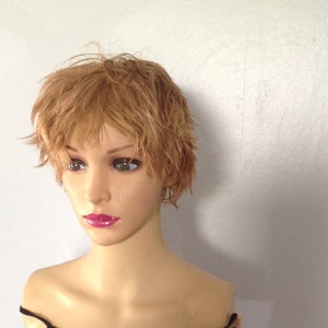 Puede incluir: Un maniquí con el pelo corto, ondulado, castaño claro, que lleva un top negro sin mangas.