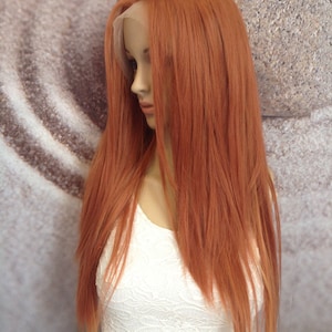 Może przedstawiać: Długa, prosta peruka w kolorze miedzianym z koronkowym przodem. Peruka jest ułożona w prosty, elegancki sposób, z przedziałkiem z boku i prostymi, opadającymi włosami.