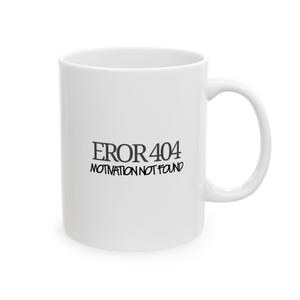 May include: A white ceramic mug featuring the black text EROR 404 MOTIVATION NOT FOUND printed on the front. The mug has a smooth, glossy finish, a cylindrical body, and a curved handle on the right side, providing a simple and functional design.