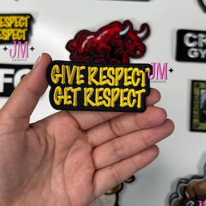 Può includere: Una collezione di toppe ricamate con vari disegni e testo. Una toppa recita "GIVE RESPECT GET RESPECT" in lettere gialle su sfondo nero. Altre toppe presentano una palla da bowling, un toro, un cane e il testo "TELL YOUR CAT I SAID PSPSPSPS".