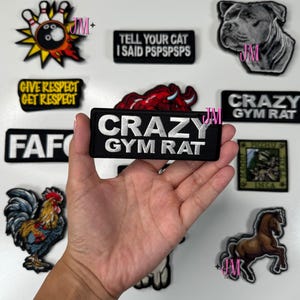 May include: A collection of embroidered patches with various designs and text. The patches include a rooster, a horse, a dog, a bowling pin, and phrases like "CRAZY GYM RAT" and "GIVE RESPECT GET RESPECT".