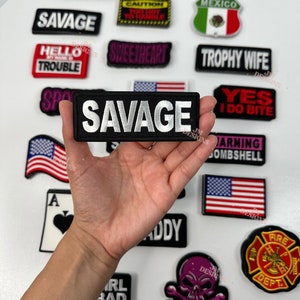 Peut inclure: Une collection de patchs thermocollants avec différents motifs et phrases, notamment "Savage", "MILF", "Trophy Wife", "Yes I Do Bite", "Warning Bombshell", "Sweetheart", "Hello My Name Is Trouble", "High Maintenance", "Girl Bad", "Daddy", "Fire Dept.", "Mexico", "Caution Too Hot To Handle", et "A".