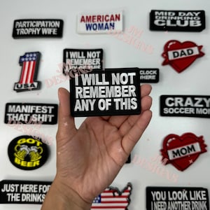 May include: A collection of embroidered iron-on patches with various designs and sayings. The patches include "I Will Not Remember Any Of This", "Participation Trophy Wife", "American Woman", "Mid Day Drinking Club", "Dad", "Crazy Soccer Mom", "Got Beer", "Just Here For The Drinks", "You Look Like I Need Another Drink", "Manifest That Shit", and "Clock Here".